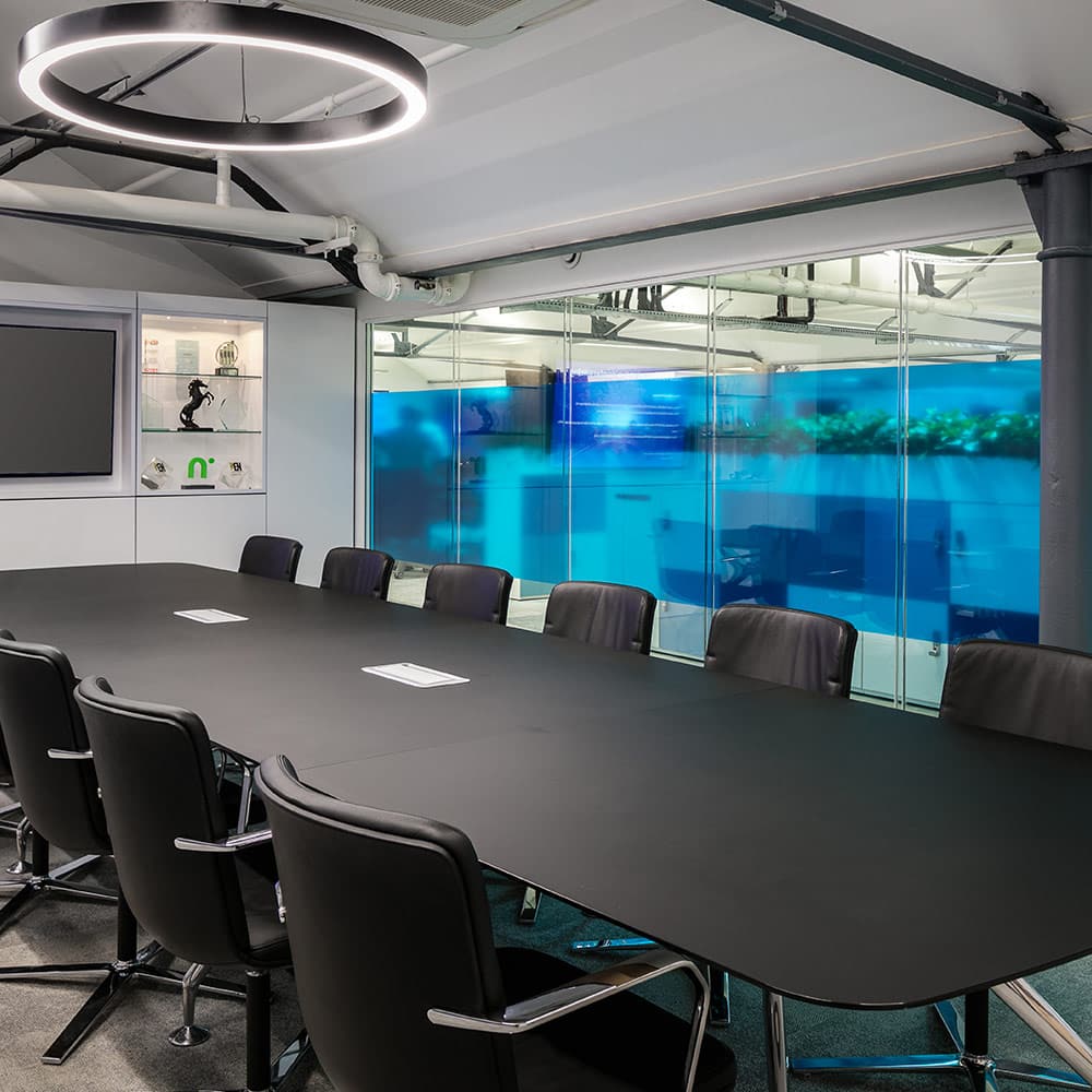 Providing optimum lux levels in office space with suspended lighting on ceiling in boardroom.
