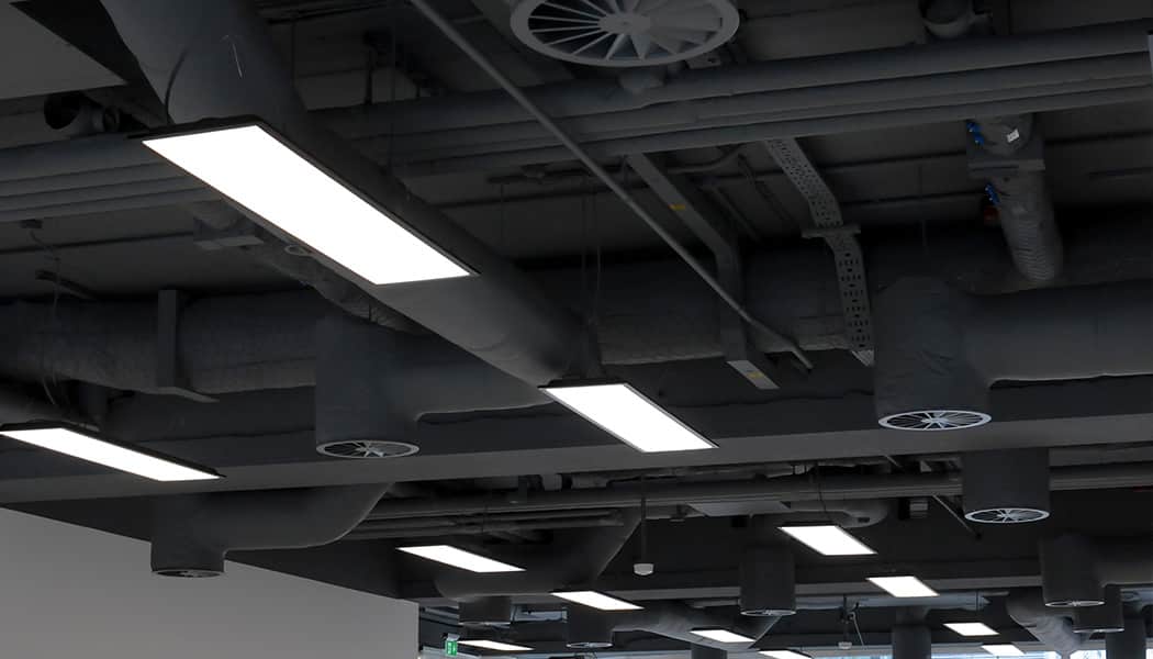 suspended lighting in office with black ceiling
